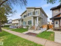 Modern two-story duplex with a distinct architectural design, featuring a light green siding exterior - 12820 68 Street, Edmonton, AB  - Outdoor 