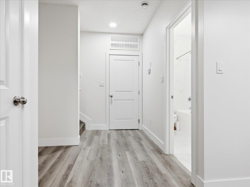 Hallway with wood-finish flooring, white walls, and recessed lighting - 12820 68 Street, Edmonton, AB - Indoor Photo Showing Other Room