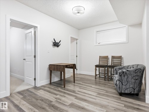 Spacious room featuring wood-finish flooring, white trim throughout, and a ceiling-mounted light fixture - 12820 68 Street, Edmonton, AB - Indoor Photo Showing Other Room