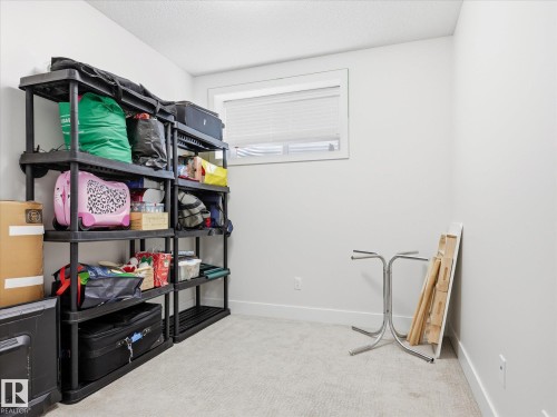 Carpeted room with a single window featuring white blinds - 12820 68 Street, Edmonton, AB - Indoor