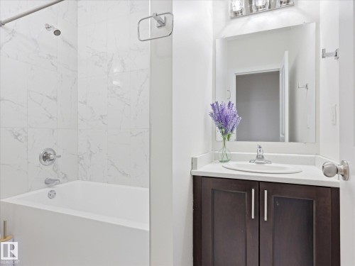 Bathroom featuring a dark wood-finish vanity with a white countertop and an integrated sink - 12820 68 Street, Edmonton, AB - Indoor Photo Showing Bathroom