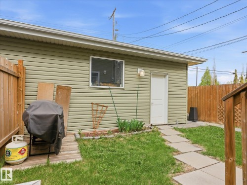 Detached garage featuring horizontal siding, a side entry door, and a single window - 12820 68 Street, Edmonton, AB - Outdoor With Exterior