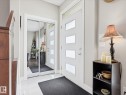 Foyer featuring a contemporary front door with privacy glass inserts, white tile flooring, and a mirrored closet with sliding doors - 12820 68 Street, Edmonton, AB  - Indoor Photo Showing Other Room 