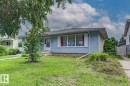 Light blue siding exterior with white trim and a contrasting stone foundation - 15707 92 Avenue, Edmonton, AB 