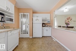 Kitchen featuring white cabinetry, light-colored countertops, and tile flooring - 