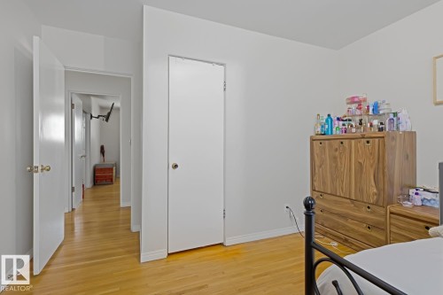Hardwood-style flooring extends through the hallway and into the room - 15707 92 Avenue, Edmonton, AB 