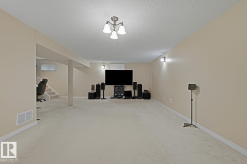 Finished lower level featuring neutral wall paint, light-colored carpet, recessed lighting, and wall-mounted sconces - 15707 92 Avenue, Edmonton, AB 