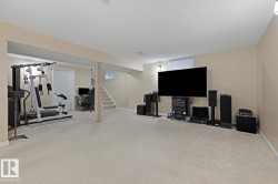 Spacious finished lower level with light-colored carpeting, neutral painted walls, and recessed lighting - 