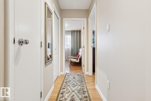 Hallway with light wood-finish flooring and neutral wall tones - 3015 131 Avenue, Edmonton, AB 