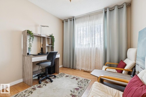 Hardwood-finish flooring featuring a window with sheer and blackout drapery - 3015 131 Avenue, Edmonton, AB 