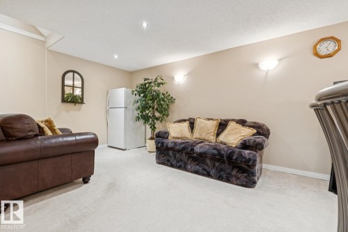Spacious carpeted room featuring recessed lighting and wall sconces - 3015 131 Avenue, Edmonton, AB 