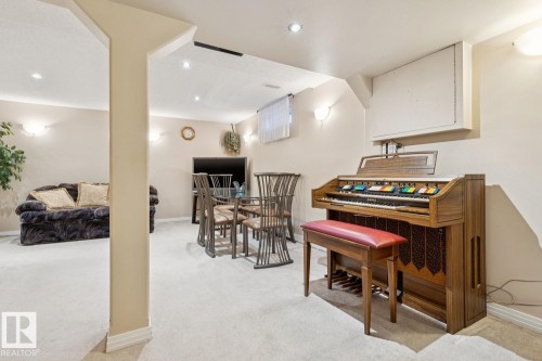 Carpeted recreation room featuring recessed lighting, wall sconces, a support column, and baseboards - 3015 131 Avenue, Edmonton, AB 