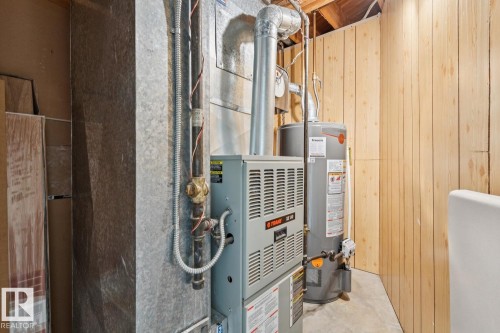 Utility area featuring a natural gas furnace, water heater, and exposed ductwork - 3015 131 Avenue, Edmonton, AB 