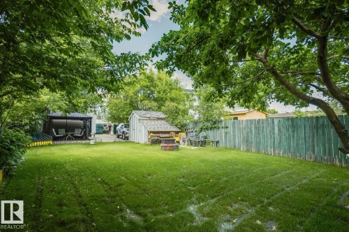Expansive green lawn with mature trees and a privacy fence - 3015 131 Avenue, Edmonton, AB 