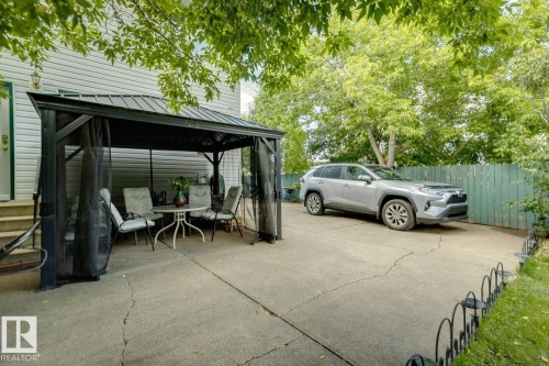 Rear exterior with light-colored siding and a covered patio area - 3015 131 Avenue, Edmonton, AB 