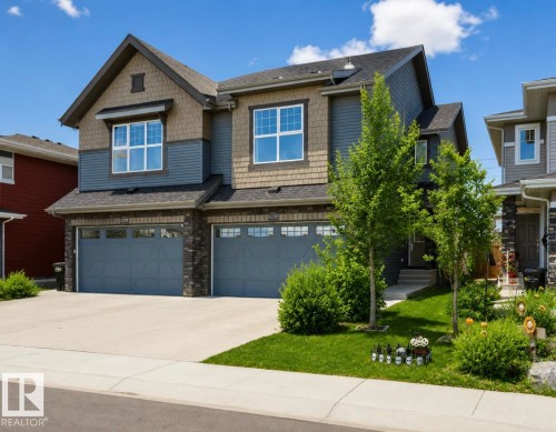 Contemporary two-story exterior featuring blue siding, shake accents, and stone veneer details - 12737 205 Street Nw, Edmonton, AB 