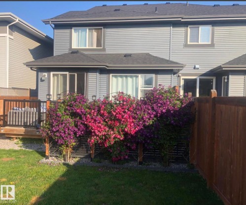 Rear exterior featuring light gray horizontal siding and a dark gray shingled roof - 12737 205 Street Nw, Edmonton, AB 