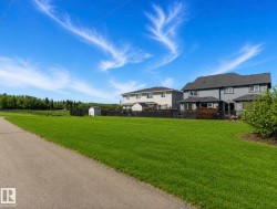 Expansive green space featuring a paved path and distant tree line - 