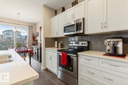 Kitchen featuring light-toned cabinetry, stainless steel appliances, and light-colored countertops - 