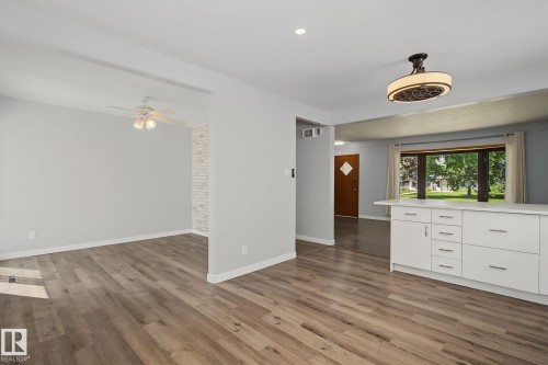 Open-concept common area featuring wood-finish flooring, recessed lighting, and a contemporary ceiling fan - 9545 65 Avenue, Edmonton, AB 