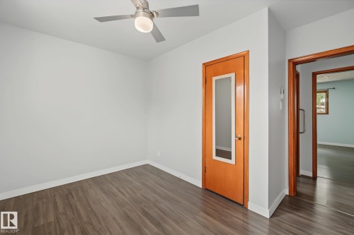 Room featuring wood-finish flooring, white baseboards, and light gray walls - 9545 65 Avenue, Edmonton, AB 
