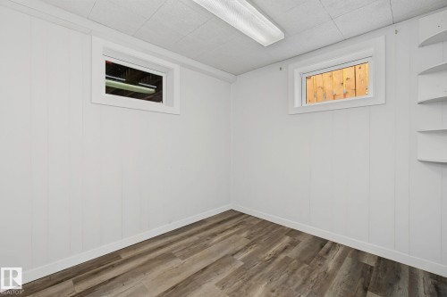 Room with wood-finish flooring, white paneled walls, and white trim - 9545 65 Avenue, Edmonton, AB 