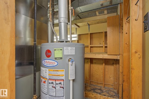 Utility area featuring a water heater, visible ductwork, and built-in shelving - 9545 65 Avenue, Edmonton, AB 