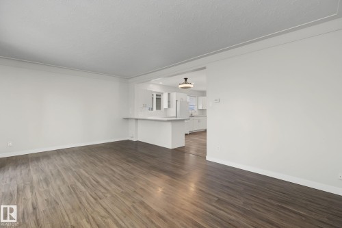Spacious living area featuring wood-finish flooring and crown molding - 9545 65 Avenue, Edmonton, AB 