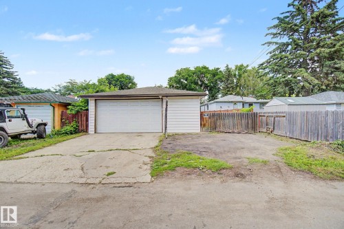 Detached garage with a single overhead door and white siding - 9545 65 Avenue, Edmonton, AB 