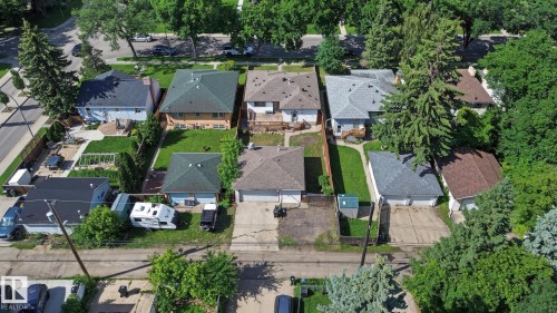 Aerial perspective showcasing multiple residential properties with pitched roofs - 9545 65 Avenue, Edmonton, AB 