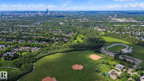 Expansive aerial perspective showcasing a verdant landscape with a city skyline in the distance - 9545 65 Avenue, Edmonton, AB 