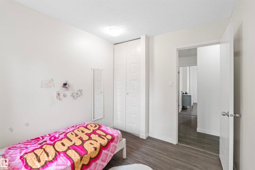 Bedroom featuring wood-finish flooring, white walls, and a ceiling light fixture - 173 Tudor Lane, Edmonton, AB 