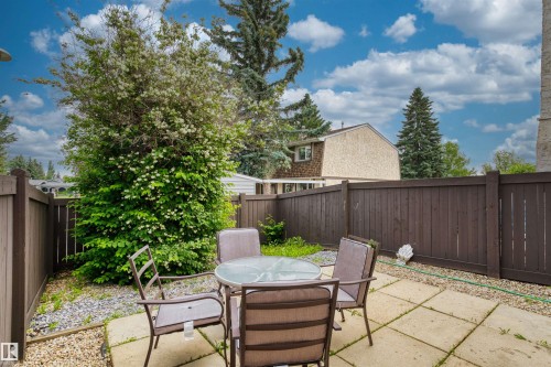 Private outdoor patio area featuring square paver stones, a gravel border, and a tall privacy fence - 173 Tudor Lane, Edmonton, AB 