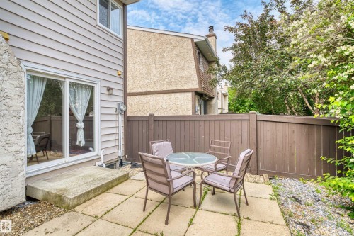 Private patio space featuring concrete pavers and a wood privacy fence - 173 Tudor Lane, Edmonton, AB 