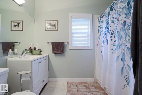 Bathroom featuring a white vanity with built-in cabinetry, a rectangular sink, and a chrome faucet - 13 7293 South Terwillegar Drive, Edmonton, AB 