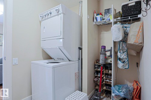 Dedicated laundry area featuring a white stackable washer and dryer unit - 13 7293 South Terwillegar Drive, Edmonton, AB 