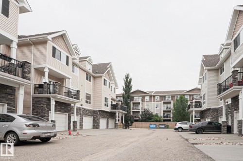 Multi-level residential buildings featuring light-toned siding and dark stone veneer accents - 13 7293 South Terwillegar Drive, Edmonton, AB 