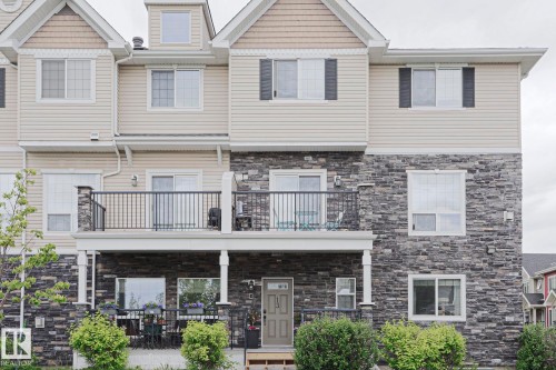 Multi-level townhome exterior featuring stone veneer and horizontal siding - 13 7293 South Terwillegar Drive, Edmonton, AB 