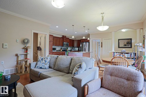 Open-concept living area with wood-finish flooring and crown molding - 13 7293 South Terwillegar Drive, Edmonton, AB 