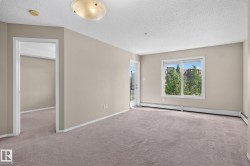 Spacious room with neutral-toned carpeting and light beige walls - 