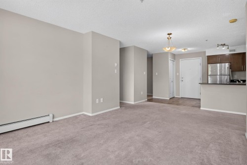 Spacious carpeted area with light neutral wall paint - 205 11816 22 Avenue, Edmonton, AB 