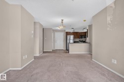 Open-concept living area with neutral carpeting and paint - 