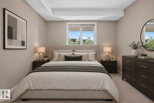 Carpeted bedroom with neutral wall tones and a window featuring white blinds - 205 11816 22 Avenue, Edmonton, AB 