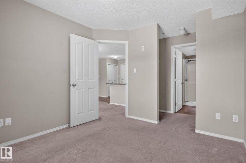 Neutral-toned walls complement the textured ceiling - 205 11816 22 Avenue, Edmonton, AB 