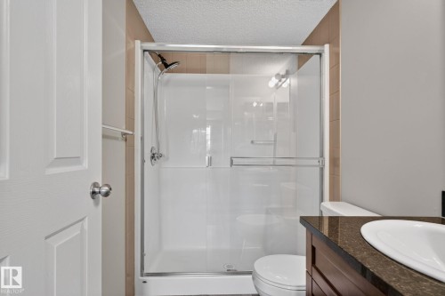 Shower enclosure with sliding glass doors, chrome fixtures, and integrated lighting - 205 11816 22 Avenue, Edmonton, AB 