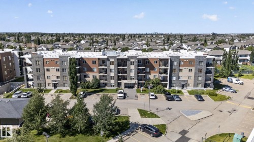Multi-story building featuring a facade of stone cladding and beige panels - 205 11816 22 Avenue, Edmonton, AB 