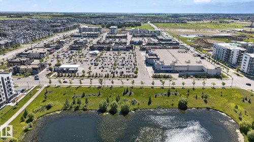 Urban landscape featuring a prominent commercial district with multiple retail buildings and extensive parking areas - 205 11816 22 Avenue, Edmonton, AB 