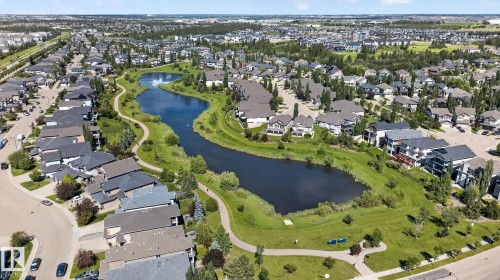 Aerial perspective showcasing a residential community with a central water feature - 205 11816 22 Avenue, Edmonton, AB 