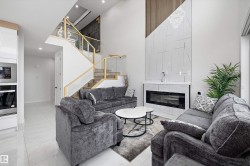 Grand living area featuring a two-story ceiling, a contemporary fireplace with a large-format tile surround, and a dramatic wood-slat accent wall - 