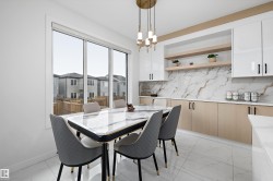 Contemporary dining area featuring a large window, white tiled flooring, and a linear chandelier - 
